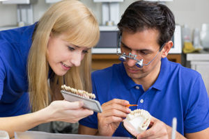 A dentist and a dental hygienist work together to create dental veneers in TX