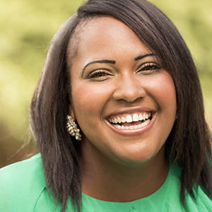 A woman smiles and laughs, showing off the dental implants services she received at Lovett Dental Webster