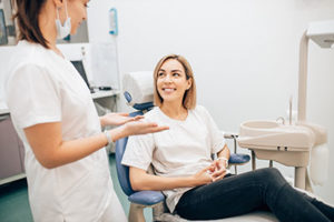 a dentist talks to a woman about apexogenesis and root canal treatment in webster tx