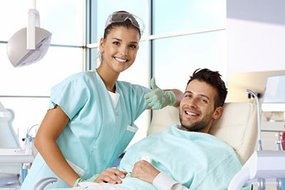 Apicoectomy webster tx a dentist and her patient smile after talking about the surgical procedure called an apicoectomy in webster tx
