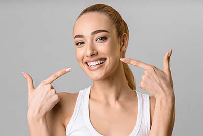happy woman pointing to her conventional dentures