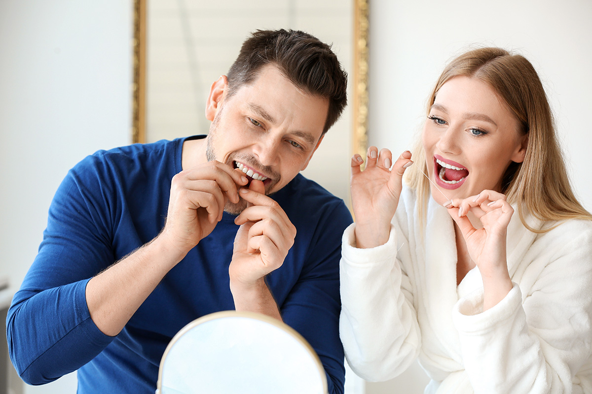 a man and woman experience the benefits of flossing daily