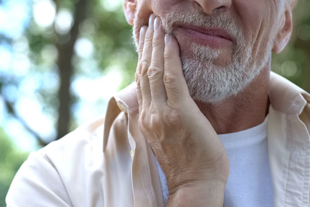 common dental problems a man holds his jaw and considers common dental problems