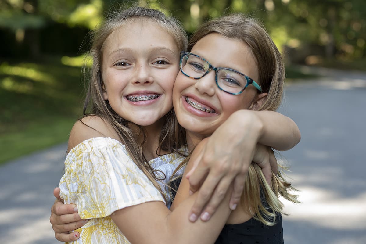 two girls show their smile with braces