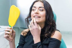 a woman checks out her new dental implants