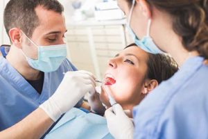 a woman receive teeth cleaning services as part of a dental cleaning in texas