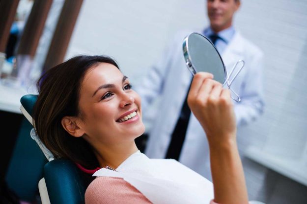 woman smiling after receiving a fluoride treatment
